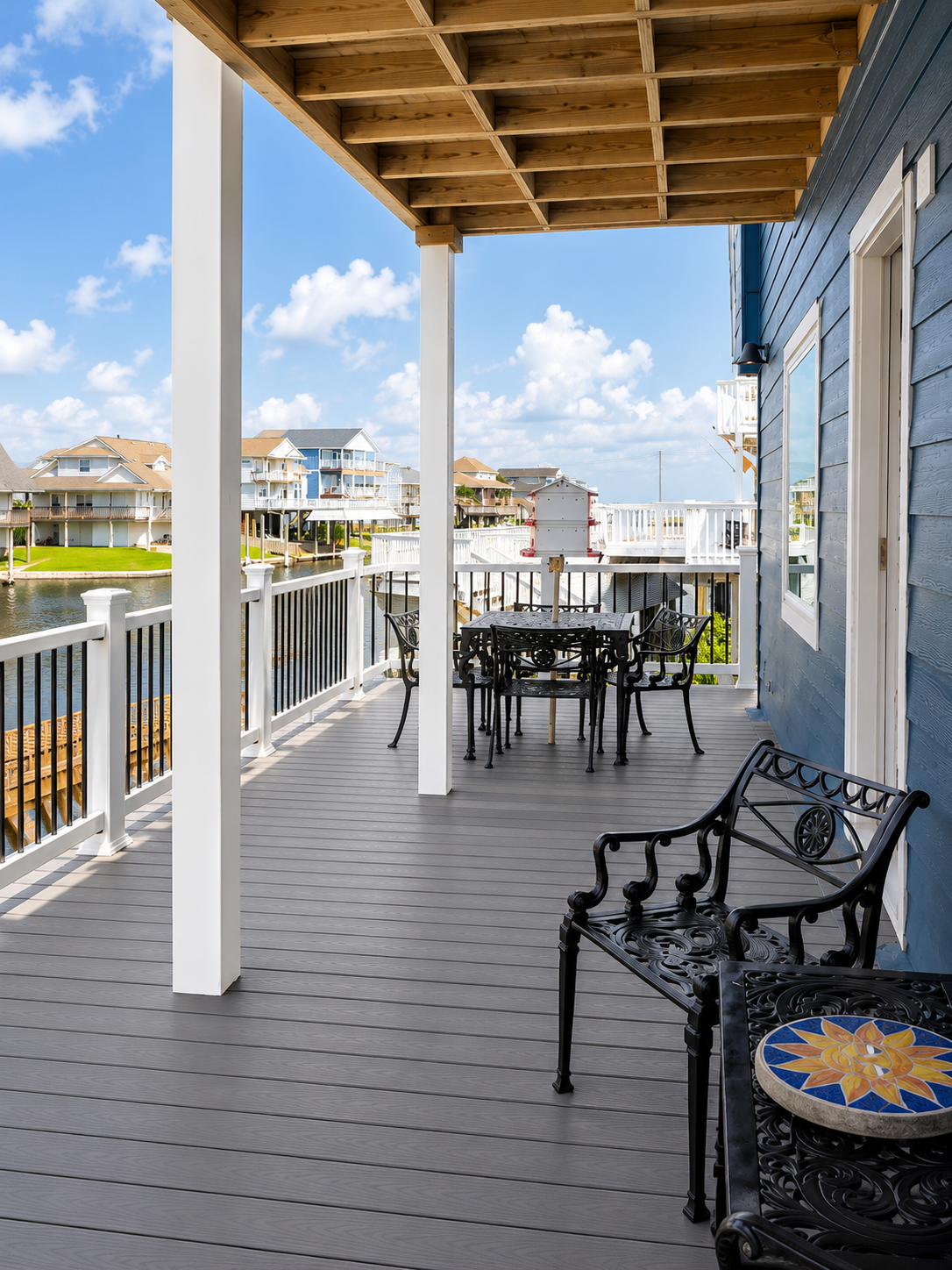 Custom composite waterfront deck with white railings and covered outdoor living space built by Mason's Quality Construction in Galveston, Texas